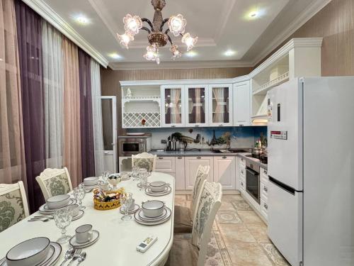 a kitchen with a table and a white refrigerator at Promenade EXPO in Astana