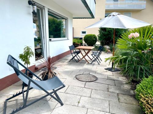 a patio with a table and chairs and an umbrella at wanderlutz in Baiersbronn