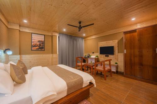 TV a/nebo společenská místnost v ubytování The Charvi Retreat I Conference I Vacations I MICE I Family Events I Open Air Terrace I Sky Bonfire I Wooden Rooms With Pvt Balconies I by Exotic Stays