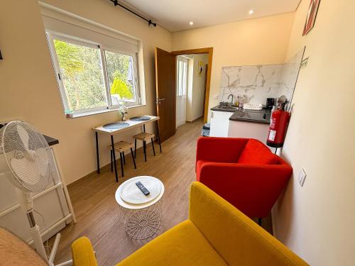 a living room with a red couch and a kitchen at Cerca do casal in Santo Tirso