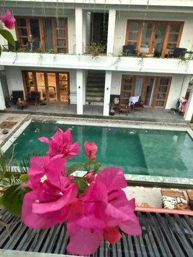 a bunch of pink flowers sitting next to a swimming pool at Nextdoor Rooms in Yogyakarta