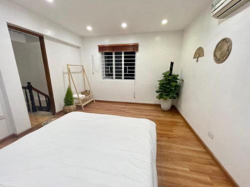 a bedroom with a white bed in a room at The Little Ha Noi - 2F Quang Trung, Hoan Kiem in Hanoi
