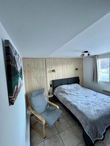 a bedroom with a bed and a chair in it at La Jassette 7 in Saint-Pierre-dels-Forcats