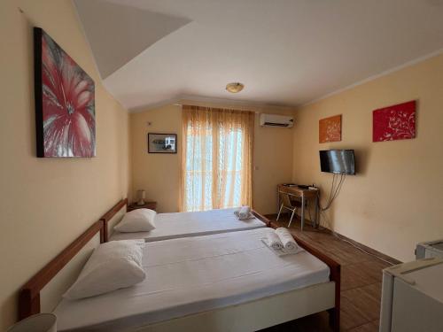 a bedroom with two beds and a television in it at Apartments Pier in Budva
