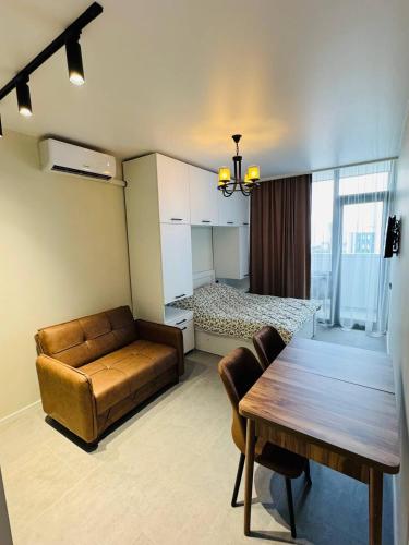 a living room with a couch and a table and a bed at Cozy Apartments with nice view in Itʼkhvisi
