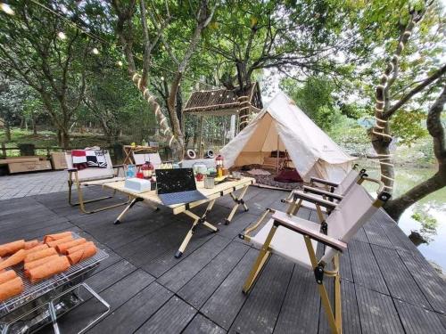 a tent on a wooden deck with a table and chairs at Lumiere Family Village Ba Vì in Ba Vì