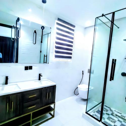 a bathroom with a sink and a glass shower at Ifemide Estates - Luxury Homes in Akure