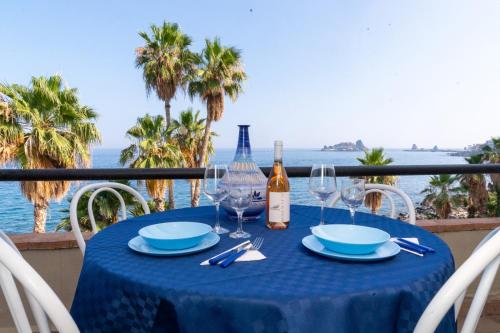 a table with a bottle of wine and glasses at Galatea Executive Sea View in Aci Castello