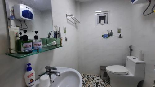 a bathroom with a white toilet and a sink at NEST HOUSE - Villa in Ấp Kim Thạch