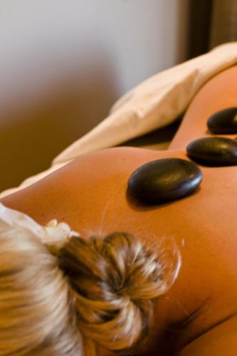 a woman with a bunch of hair on her back with spa stones at Guesthouse Looierij de Luxe - privé wellness in Dongen