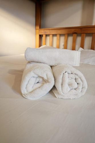 a pile of towels sitting on top of a bed at Casa e Kitnets Imbituba Praia da Vila in Imbituba
