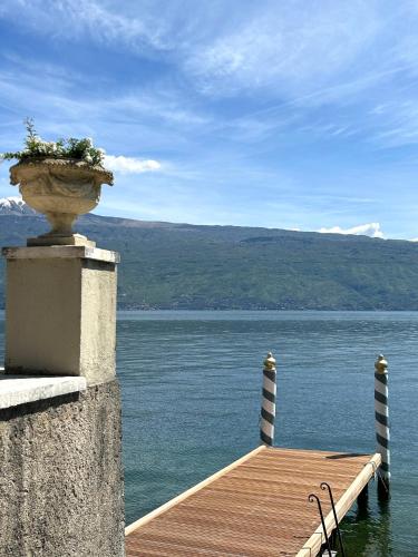 a wooden dock with a planter on the water at Hotel Villa Giulia in Gargnano