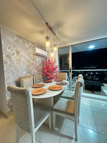 a dining room with a white table and chairs at Apartamento exclusivo en el norte Barranquilla amoblado ,3 parqueadero privados ,3 habitaciones privadas con aire acondicionado recepción 24 horas piscinas gym vista al río in Barranquilla