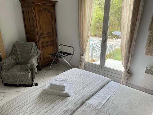 a bedroom with a bed and a chair and a window at Villa Lola in Bargemon