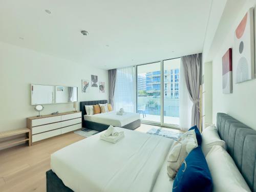 a bedroom with two beds and a large window at Azure Saadiyat 2BR plus Maids room with Views in Abu Dhabi