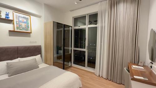 a bedroom with a bed and a large window at Seri Alam Cozy Studio by YHA in Masai