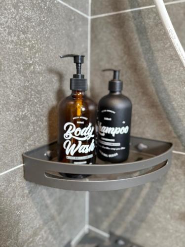 two bottles of soap on a shelf in a bathroom at Seri Alam Cozy Studio by YHA in Masai