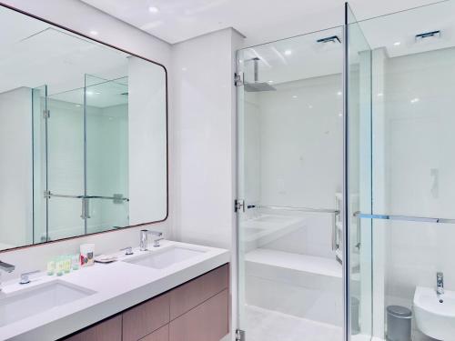 a bathroom with a glass shower and a sink at Azure Saadiyat 2BR plus Maids room with Views in Abu Dhabi