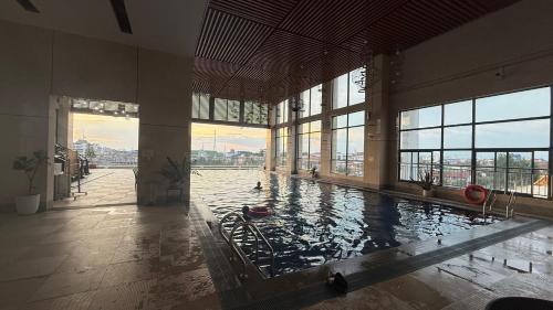 a large swimming pool in a large building with windows at NAGA Frontier in Vientiane
