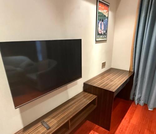 a living room with a large flat screen tv on a wall at NAGA Frontier in Vientiane