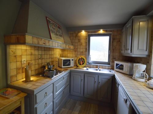 ファラエンにあるHoliday Home in Falaën near Montaigle Castleの白いキャビネット、シンク、窓付きのキッチン