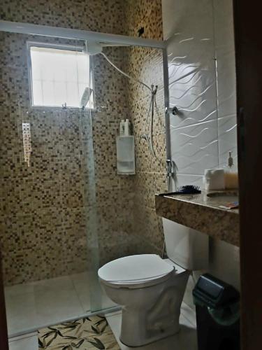 a bathroom with a toilet and a shower at Apartamento na praia 2 qt com quintal e churrasqueira in Itanhaém