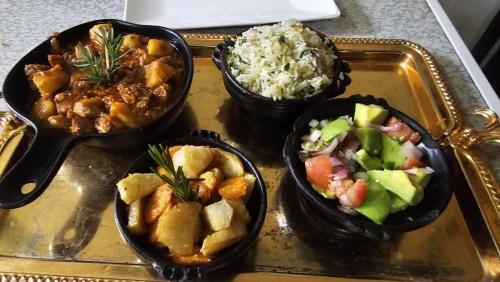 three bowls of food on a tray with rice at Hanom Hotel in Addis Ababa