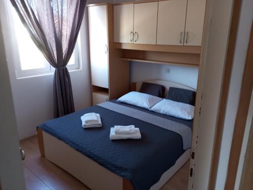 una camera da letto con un letto con due asciugamani sopra di Apartmani Ćućić a Lopar
