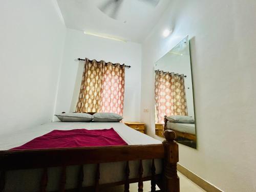 a bedroom with a bed with a mirror and curtains at The Mystic Cliff Varkala in Varkala