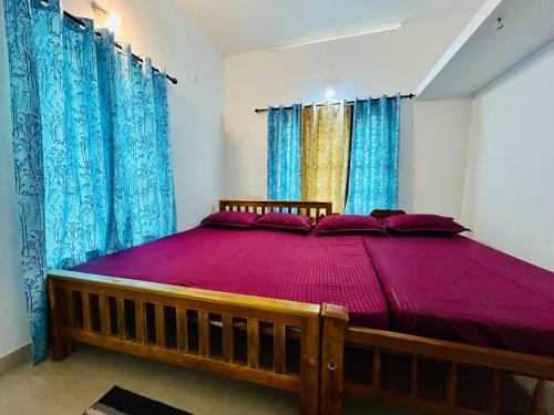 a large wooden bed in a room with blue curtains at The Mystic Cliff Varkala in Varkala