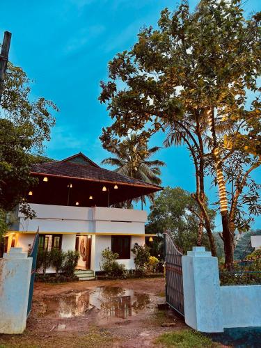 a house with a fence and a tree at The Mystic Cliff Varkala in Varkala