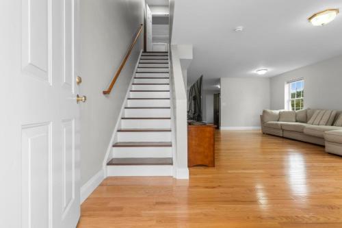 a white staircase in a living room with a couch at Near YALE - Beautiful Waterfront Townhouse in New Haven in New Haven