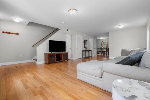 a living room with a couch and a flat screen tv at Near YALE - Beautiful Waterfront Townhouse in New Haven in New Haven