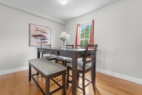 a dining room table with chairs and a vase of flowers at Near YALE - Beautiful Waterfront Townhouse in New Haven in New Haven