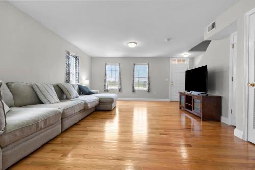 a living room with a couch and a flat screen tv at Near YALE - Beautiful Waterfront Townhouse in New Haven in New Haven
