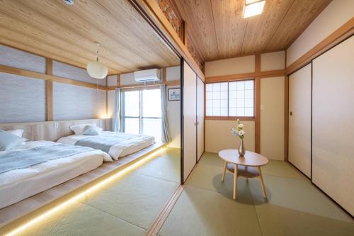 a bedroom with two beds and a table in it at Breeze Stay Shiohama in Tokyo
