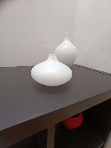 two white vases sitting on top of a table at A casa di Irene in Le Marmore