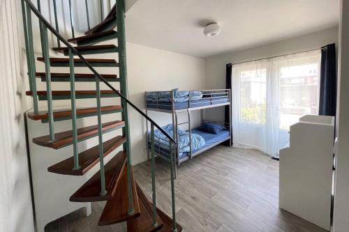 a room with a staircase with bunk beds in it at Sleedoornstraat 3 in Cadzand