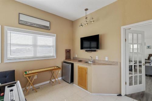 a kitchen with a counter and a tv on the wall at It's A Vibe in Kitty Hawk