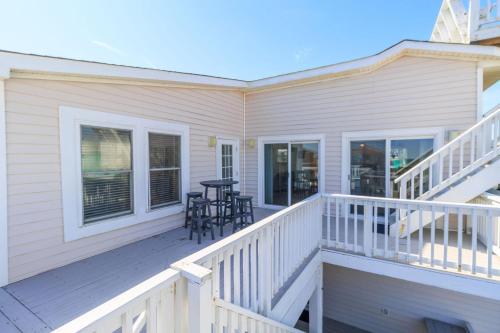 a porch with chairs and a table on a house at It's A Vibe in Kitty Hawk