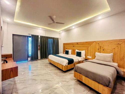 a hotel room with two beds and a tv at Cliff On The Edge - A Premium Property in Mussoorie