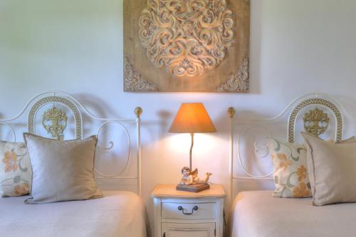 a bedroom with two beds and a lamp on a table at Monte Do Caneiro in Mourão