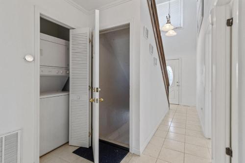 a white hallway with a closet and a door at It's A Vibe in Kitty Hawk