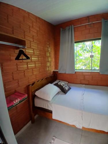 a small room with a bed with a window at Hostel Sossego do Garças in Barra do Garças