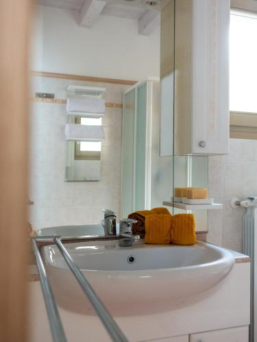a bathroom with a sink with yellow towels on it at Casa Raki in Parzanica