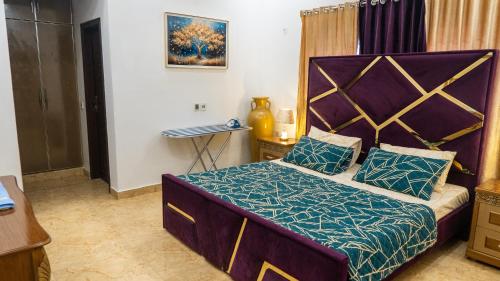 a bedroom with a large bed with a large headboard at Cozy 2-Bed Lower Portion with Kitchen & Parking in Lahore