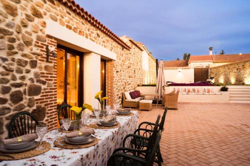 einen Tisch für eine Mahlzeit auf einer Terrasse in der Unterkunft El Corral de Cayetana in Valdemierque