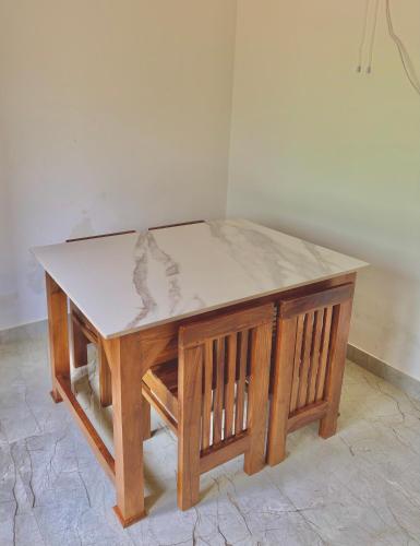 a wooden table with a marble top on top at Grove Stay in Chakkarakkal