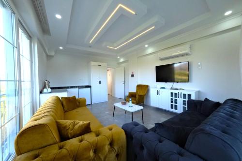 a living room with a couch and a tv at The Dalaman Suites & Pansiyon Dalaman Airport 10 km in Dalaman