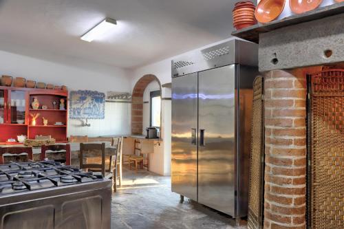 a kitchen with a stainless steel refrigerator and a brick wall at Monte Do Caneiro in Mourão